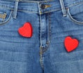 Two red wooden hearts on blue jeans Royalty Free Stock Photo