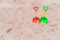Green and red plastic shovels on the beach Royalty Free Stock Photo