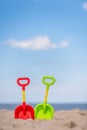 Green and red plastic shovels on the beach Royalty Free Stock Photo