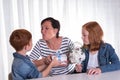 Two redhaired kids giving a present to their mother