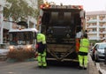 Two refuse collection workers loading garbage into waste truck emptying containers Royalty Free Stock Photo