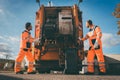 Two refuse collection workers loading garbage into waste truck Royalty Free Stock Photo