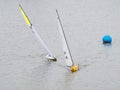 Two remote controlled yachts near buoy.