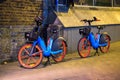 Two rental electric bikes parked on sidewalk at night Royalty Free Stock Photo