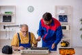 Two male repairmen repairing air-conditioner