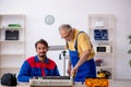 Two male repairmen repairing air-conditioner