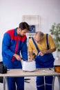 Two male repairmen working at workshop