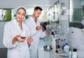 Two researchers in white coat checking wine acidity in laboratory