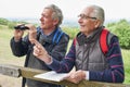 Two Retired Male Friends On Walking Holiday Looking Through Binoculars Royalty Free Stock Photo