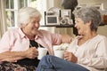 Two Retired Senior Female Friends Sitting On Sofa Drinking Tea At Home Royalty Free Stock Photo