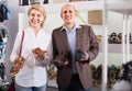 Two retirees together choosing pair of shoes in fashion store Royalty Free Stock Photo