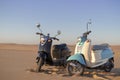 Two Retro scooters at sunset in the golden sand of the Namib Desert Royalty Free Stock Photo