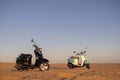 Two scooters at sunset in the golden sand of the Namib Desert Royalty Free Stock Photo