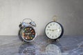 Two retro table clocks with reflection on polished marble surface Royalty Free Stock Photo