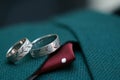 Two rings on green male wedding suit. Macro close up of wedding rings