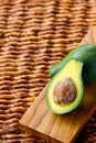 Two ripe avocados on wooden background: one whole and one cut. Royalty Free Stock Photo