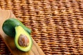 Two ripe avocados on wooden background: one whole and one cut. Royalty Free Stock Photo