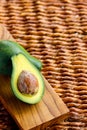 Two ripe avocados on wooden background: one whole and one cut. Royalty Free Stock Photo