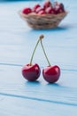 Two ripe fresh cherries and wicker plate on the background. Royalty Free Stock Photo