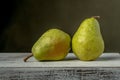 Two ripe green pears placed side by side.