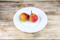 Two ripe pears in white plate on rustic wooden table Royalty Free Stock Photo