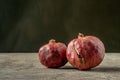 Two ripe pomegranates on dark backgrounds
