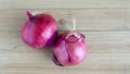 Two ripe red onions on a wooden table with copy space Royalty Free Stock Photo