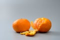 Two ripe tangerine fruits on a gray background