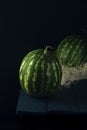 Two ripe watermelons on dark blue wooden table