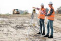 Road construction workers using measuring device on the field