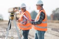 Road construction workers using measuring device on the field