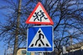 Two road signs a pedestrian crossing and caution children on the background of gray branches