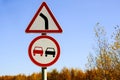 Two road signs warning no overtaking and turning right against a blue sky Royalty Free Stock Photo