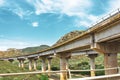 Two road turn highway bridge, viaduct supports in the valley among the green hills, transport infrastructure