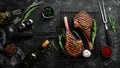 Two roast beef steaks on the bone with spices and herbs. On a black stone background. Top view. Free copy space Royalty Free Stock Photo