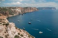 Two rocks stick out of the water in the middle of the turquoise sea. Scenic ocean view. Speed boat sails on the sea