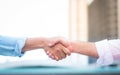 Two roll up shirt sleeves businessman shaking hands agreement with blurred building background Royalty Free Stock Photo