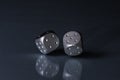 Two Rolling Silver Casino Dice on Black Background with blue bottom Royalty Free Stock Photo