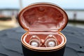 two rose gold wedding rings inside a pearl-filled oyster shell on a boat deck