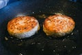 Two round cutlets from meat of beef are fried in a frying pan and oil. Royalty Free Stock Photo