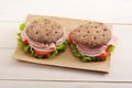 Two round sandwich of rye bread with ham, tomato and lettuce on Royalty Free Stock Photo