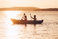 Two rowers on inflatable kayak rowing by the evening sunset rays Adriatic sea harbor in Croatia near Sibenik city. Vacation, Royalty Free Stock Photo