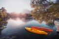 rowing boats kayaks without people are bobbing on the waves moored to the shore with a view of the rising sun over the Royalty Free Stock Photo