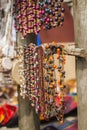 Two Rows of beautiful African bead necklaces hanging from wooden branches in an open air market