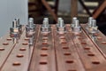 Two rows of bolts with washers and nuts fixed in busbars.