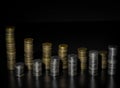 Two rows of coin stacks. Silver and gold coin stacks isolated on dark background