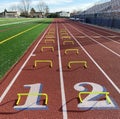 Two rows of eight yellow mini hurdles set up on a red track at the 100 meter start line