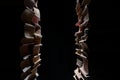 Two rows of old books in the dark on a black isolated studio background. Silhouette of stacked stacks of books with Royalty Free Stock Photo