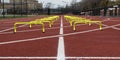 Two rows of six inch yellow hurdles on a track