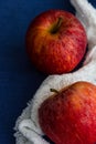 Two royal gala apples with a white cloth against a blue background. Close up, copy space Royalty Free Stock Photo